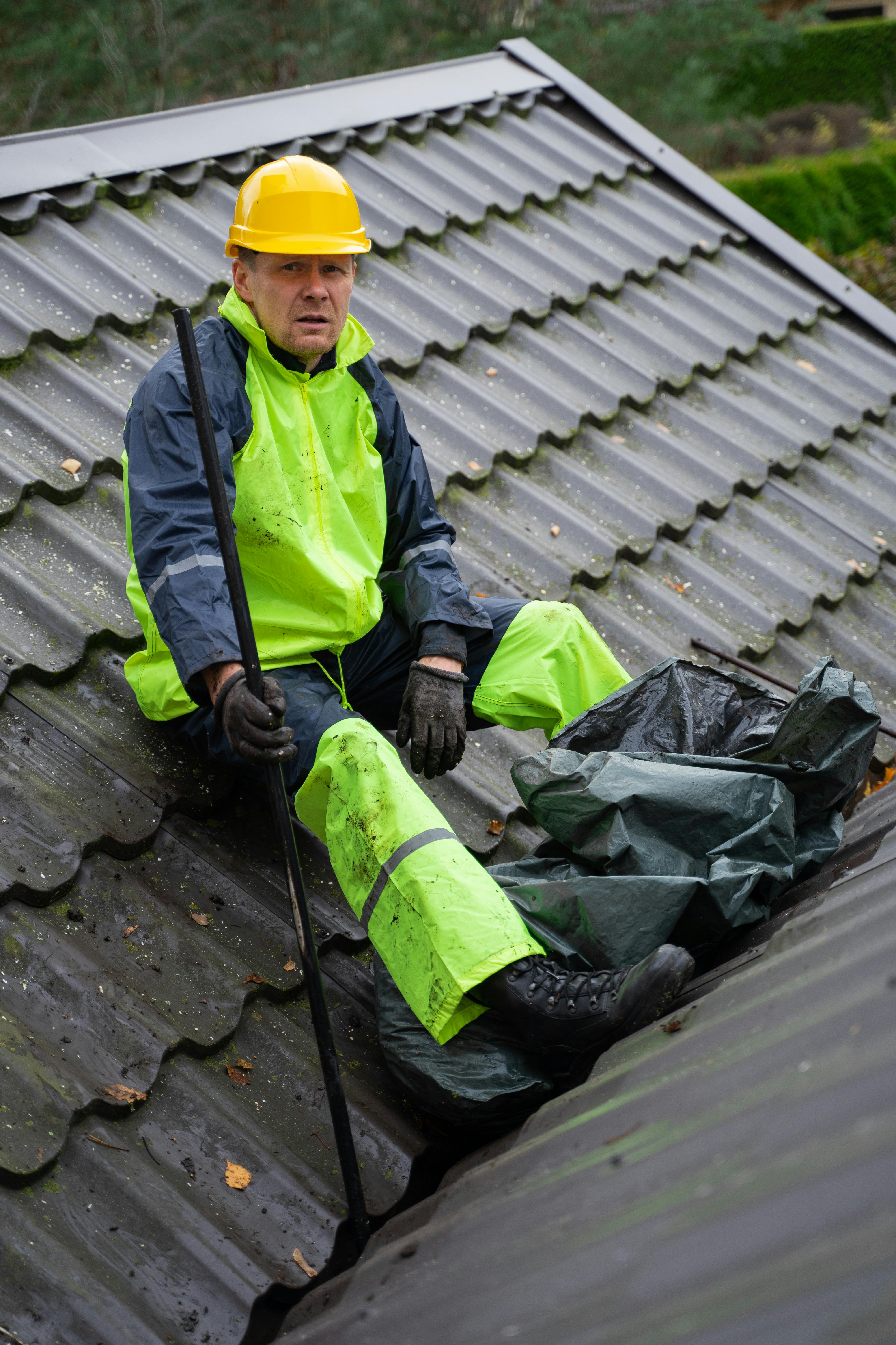 New roof installation with worker laying shingles